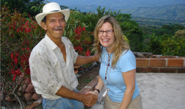 A cacao farmer shaking hands with a sweetriot founder on a farm